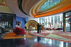 
The entrance of Burj Al Arab has large curved red leather seats, yellow carpet, with a blue floor.
